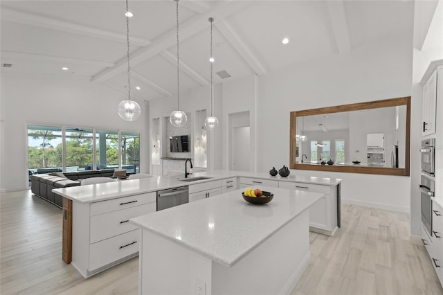 kitchen with high vaulted ceiling, stainless steel dishwasher, and white cabinets