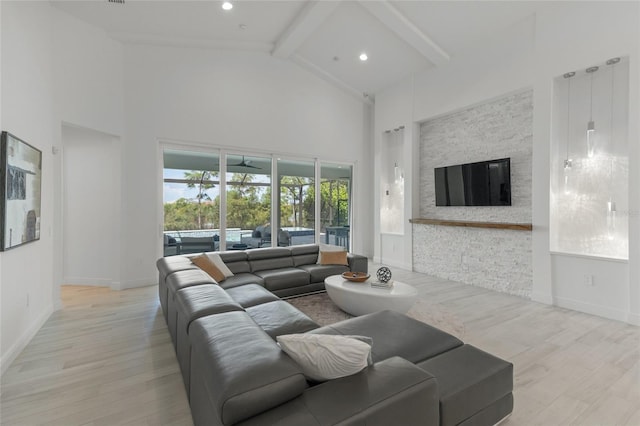 living room featuring high vaulted ceiling, a fireplace, beamed ceiling, and light hardwood / wood-style flooring