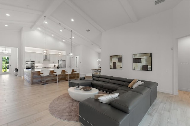 living room featuring high vaulted ceiling, an inviting chandelier, beamed ceiling, and light hardwood / wood-style flooring