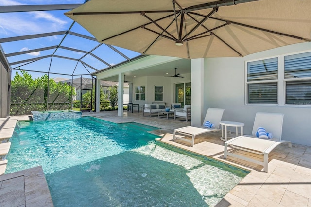 view of pool featuring a patio area, glass enclosure, pool water feature, outdoor lounge area, and ceiling fan