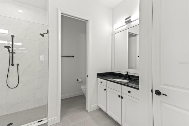 bathroom with vanity, toilet, and a tile shower