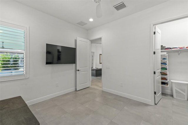 interior space with light tile patterned flooring, ceiling fan, and a closet