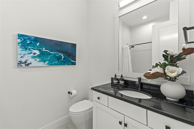 bathroom featuring walk in shower, toilet, and vanity