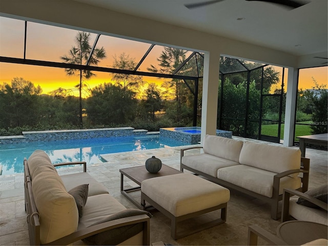 pool at dusk featuring an outdoor living space, glass enclosure, and a patio area