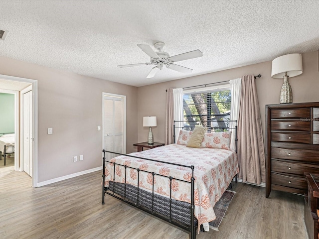 bedroom featuring ceiling fan, a textured ceiling, hardwood / wood-style flooring, and a closet