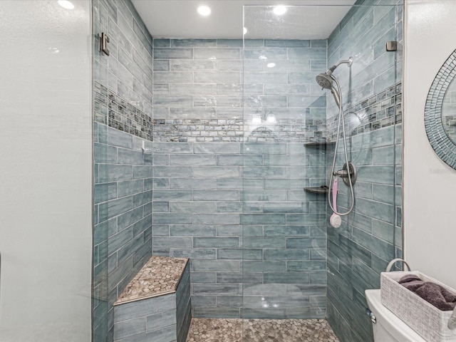 bathroom with toilet and a tile shower