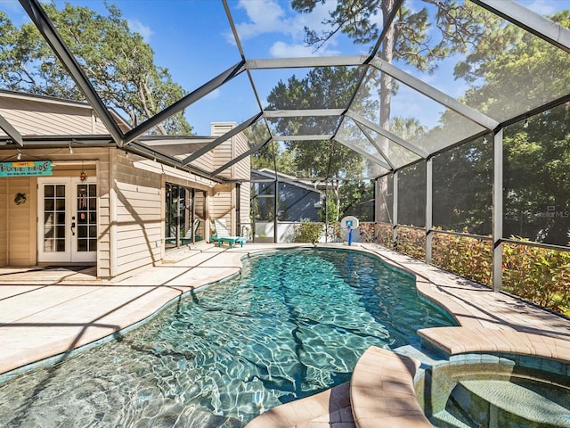 view of swimming pool featuring a patio area, a lanai, an in ground hot tub, and french doors