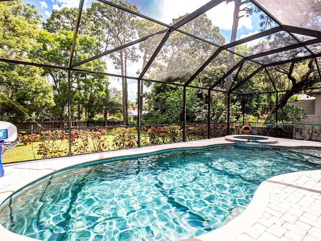 view of pool with an in ground hot tub, a patio area, and glass enclosure