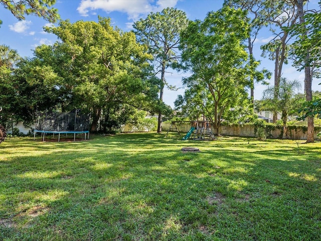 view of yard featuring a trampoline and a playground