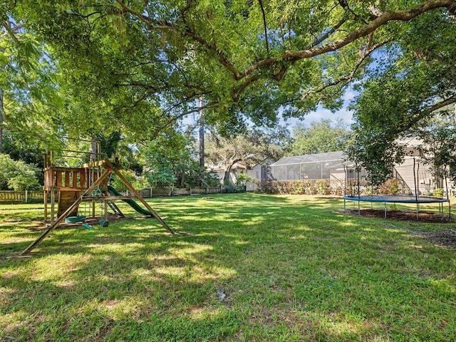 view of yard featuring a playground and a trampoline