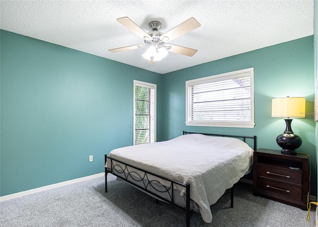 carpeted bedroom featuring ceiling fan and a textured ceiling