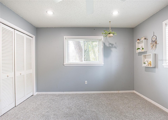 interior space with carpet, a closet, and a textured ceiling