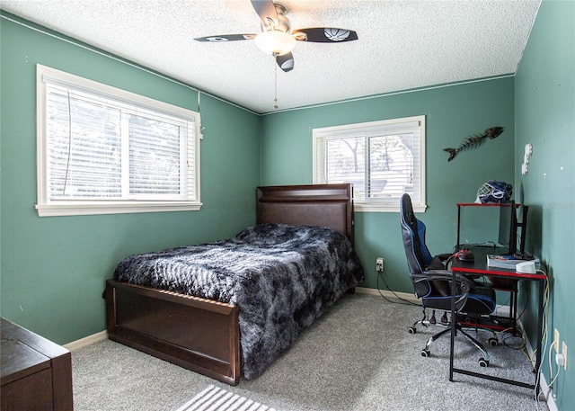 bedroom featuring ceiling fan, a textured ceiling, and carpet flooring