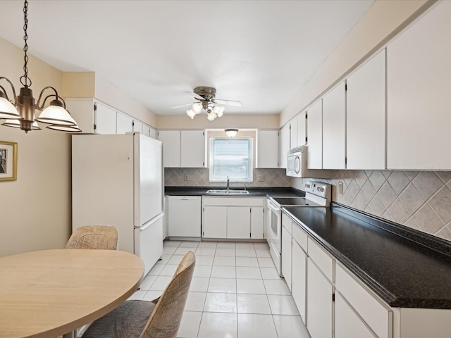 kitchen with ceiling fan with notable chandelier, white appliances, white cabinetry, sink, and tasteful backsplash