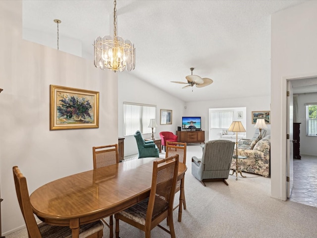 carpeted dining area featuring ceiling fan with notable chandelier, a textured ceiling, and vaulted ceiling