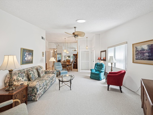 carpeted living room featuring a textured ceiling and ceiling fan