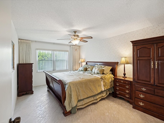 bedroom featuring a textured ceiling, ceiling fan, and light wood-type flooring