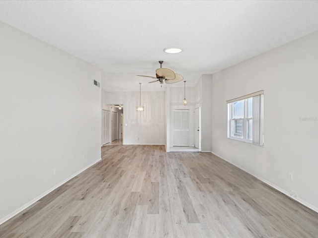 unfurnished living room with a textured ceiling, ceiling fan, and light hardwood / wood-style flooring