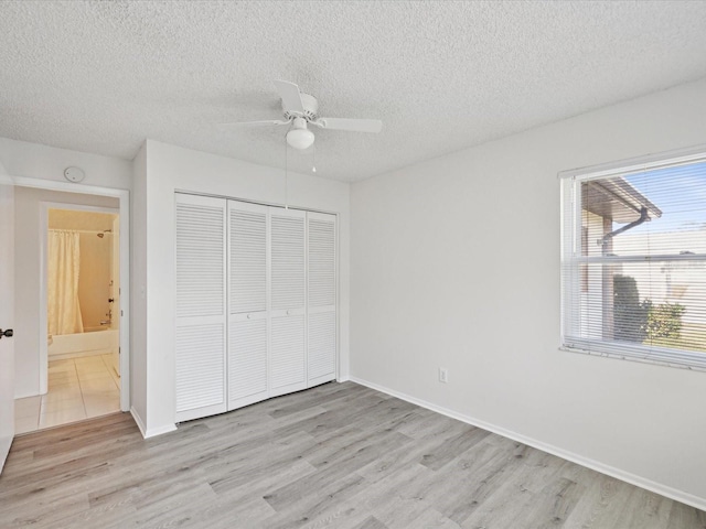 unfurnished bedroom with a closet, ceiling fan, a textured ceiling, and light hardwood / wood-style flooring