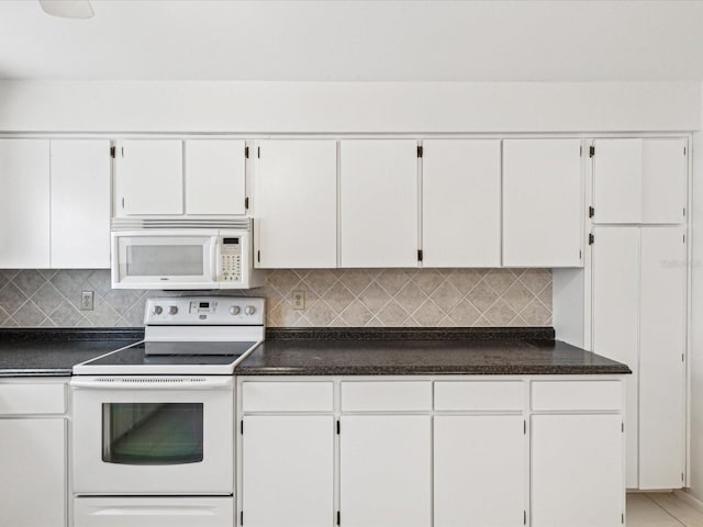 kitchen featuring tasteful backsplash, white cabinets, and white appliances