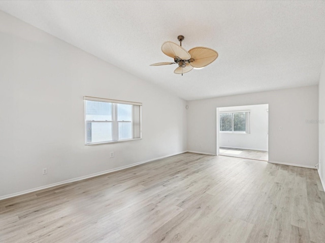 unfurnished room with ceiling fan, lofted ceiling, a textured ceiling, and light hardwood / wood-style floors