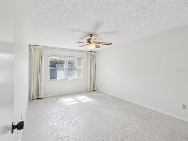 unfurnished room with ceiling fan, a textured ceiling, and light wood-type flooring