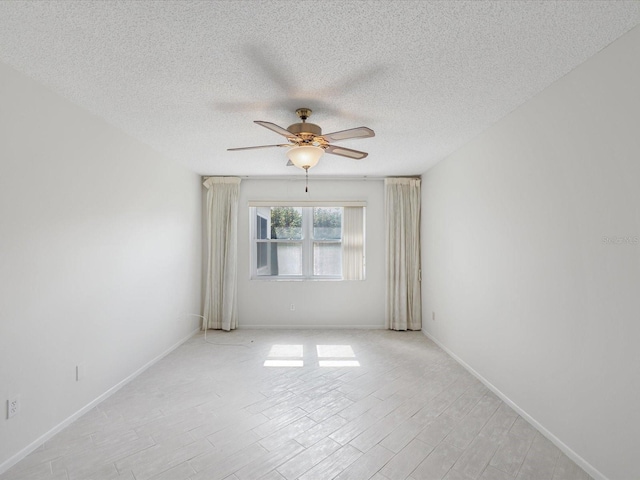 unfurnished room with ceiling fan, a textured ceiling, and light wood-type flooring