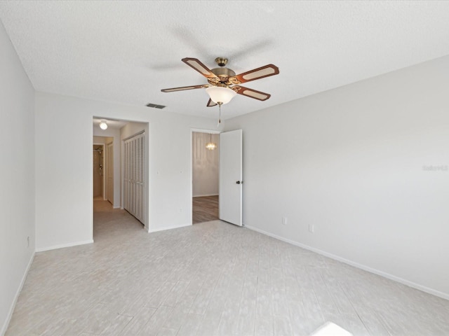 empty room with a textured ceiling and ceiling fan