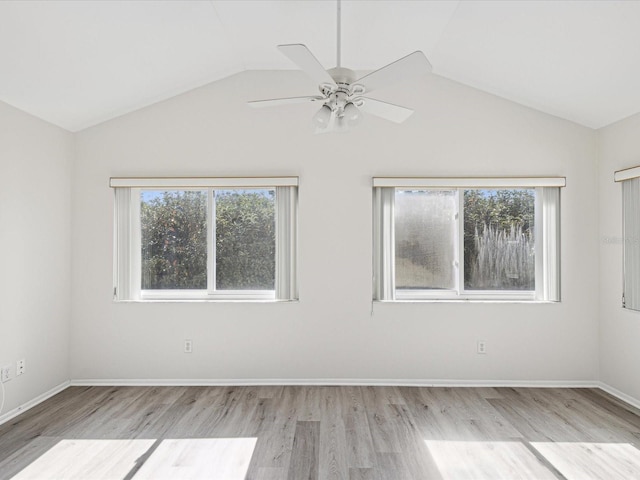 spare room with ceiling fan, vaulted ceiling, and light wood-type flooring