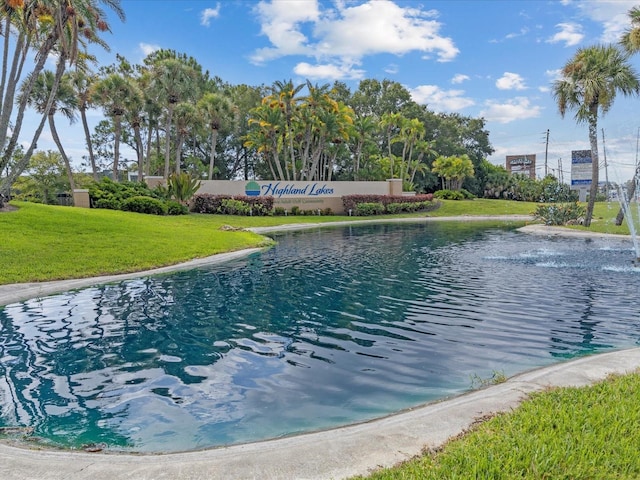 view of pool with a lawn