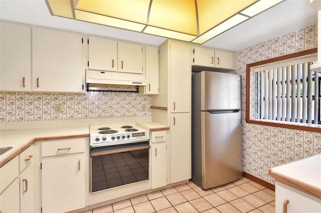 kitchen with stainless steel fridge, light tile patterned floors, and electric range