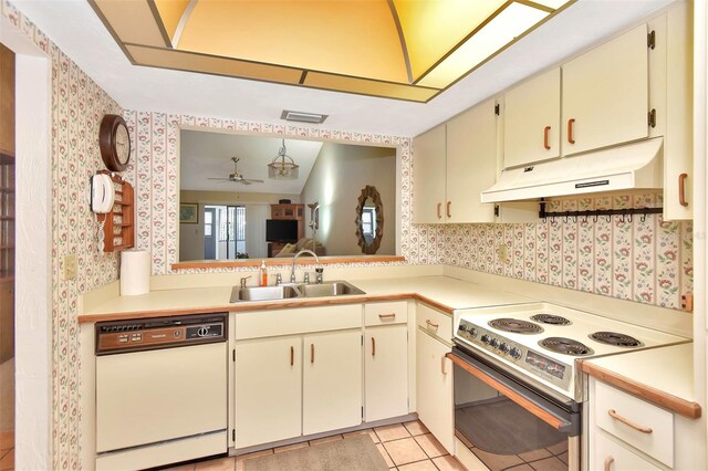 kitchen featuring white appliances, sink, ceiling fan, vaulted ceiling, and light tile patterned flooring