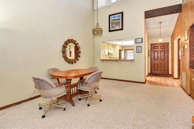 carpeted dining space with high vaulted ceiling