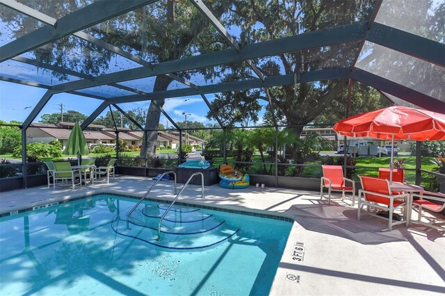 view of swimming pool featuring a lanai and a patio area