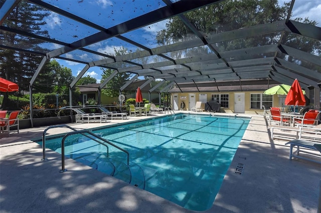 view of swimming pool featuring glass enclosure and a patio