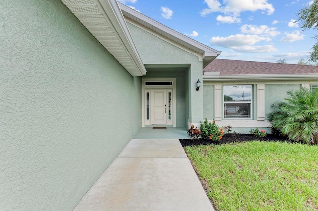 view of exterior entry featuring a lawn