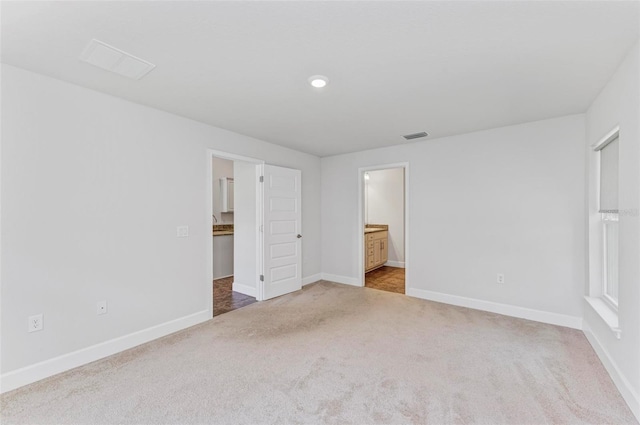 unfurnished bedroom featuring carpet floors and ensuite bath