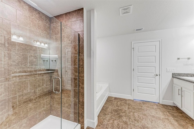 bathroom with tile patterned flooring, vanity, independent shower and bath, and a textured ceiling