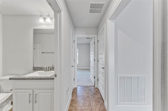 bathroom featuring vanity, toilet, and tile patterned floors