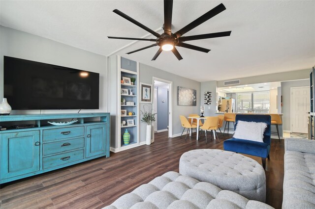 living room featuring built in features, ceiling fan, dark hardwood / wood-style floors, and a textured ceiling