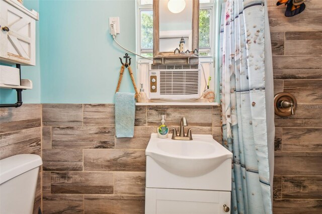 bathroom with walk in shower, vanity, toilet, and cooling unit