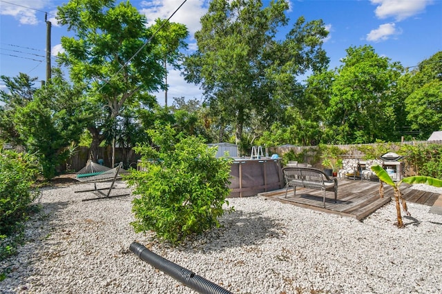 6220 5th Ave S, Saint Petersburg, FL 33707 - view of yard with an outbuilding, a deck, a storage unit, and a fenced backyard