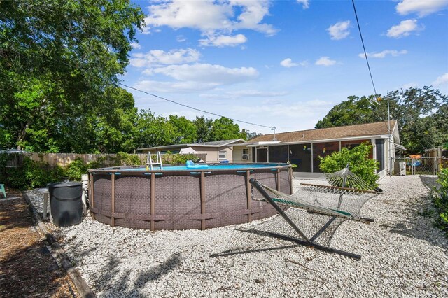 exterior space featuring a sunroom and a fenced in pool