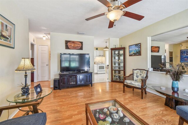 living room featuring light wood-type flooring and ceiling fan