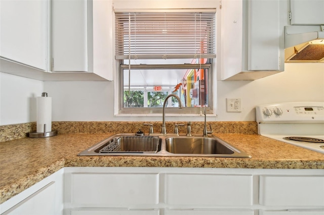 kitchen featuring sink, white cabinets, and range hood