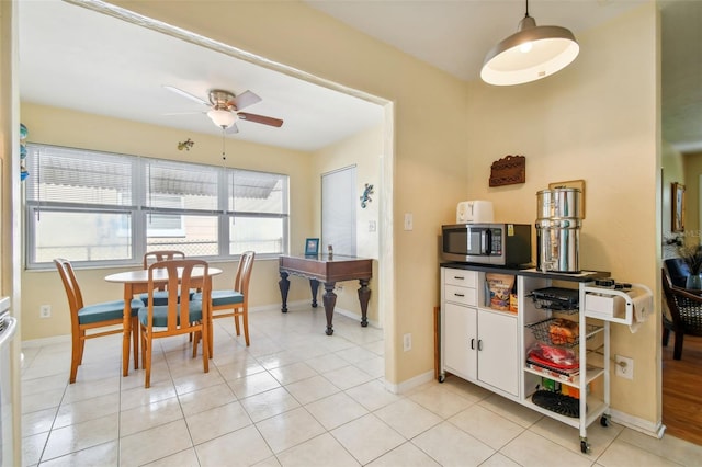 kitchen featuring white cabinets, ceiling fan, and light tile patterned floors