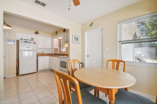 dining space with ceiling fan, light tile patterned floors, and sink