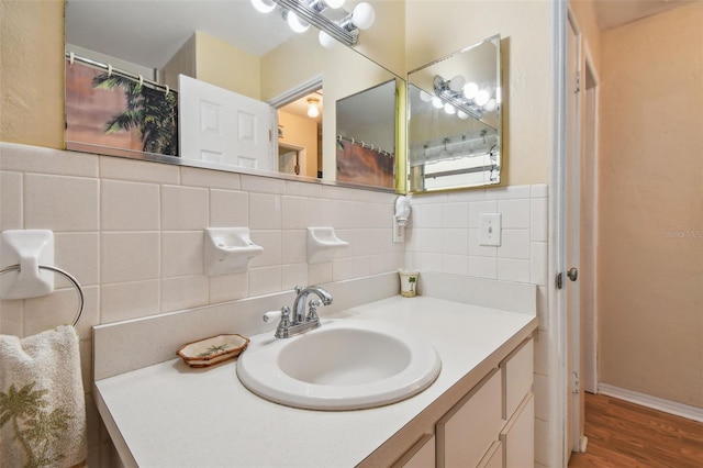 bathroom with hardwood / wood-style flooring, decorative backsplash, and vanity