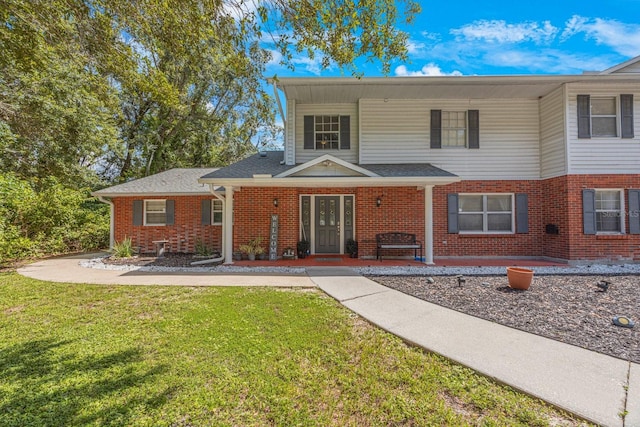 view of front of home featuring brick siding and a front lawn
