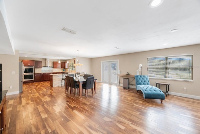 dining room with visible vents, light wood finished floors, baseboards, recessed lighting, and french doors
